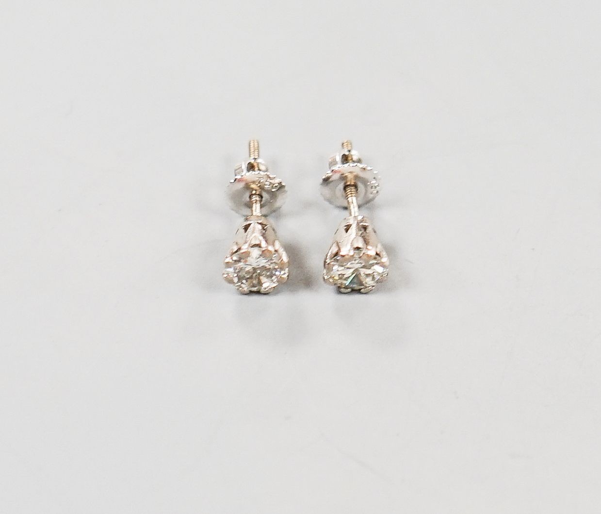 A pair of 750 white metal and solitaire diamond ear studs, gross weight 2 grams